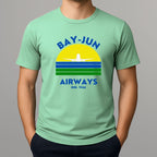 Person wearing a light green t-shirt with 'Bay-Jun Airways' design on a gray background