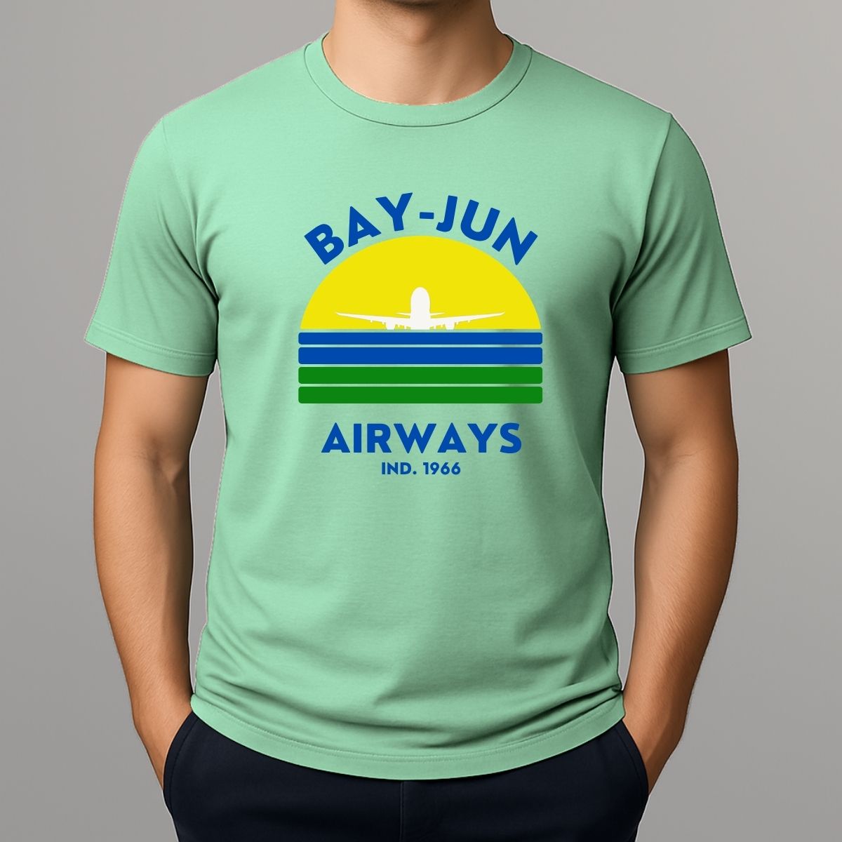 Person wearing a light green t-shirt with 'Bay-Jun Airways' design on a gray background
