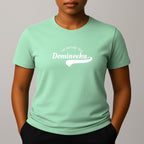 Person wearing a mint green t-shirt with a white graphic print that reads 'THE NATURE ISLE' and a phonetic spelling of 'DOMINEEKA'.