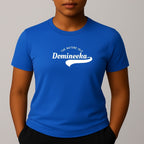 Person wearing a blue t-shirt with a white graphic print that reads 'THE NATURE ISLE' and a phonetic spelling of 'DOMINEEKA'.