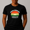 Person wearing a black short-sleeve T-shirt with a retro-style graphic reading 'DOMI-NEEKUN AIRWAYS' and 'IND. 1978' over a striped sunset and airplane silhouette.