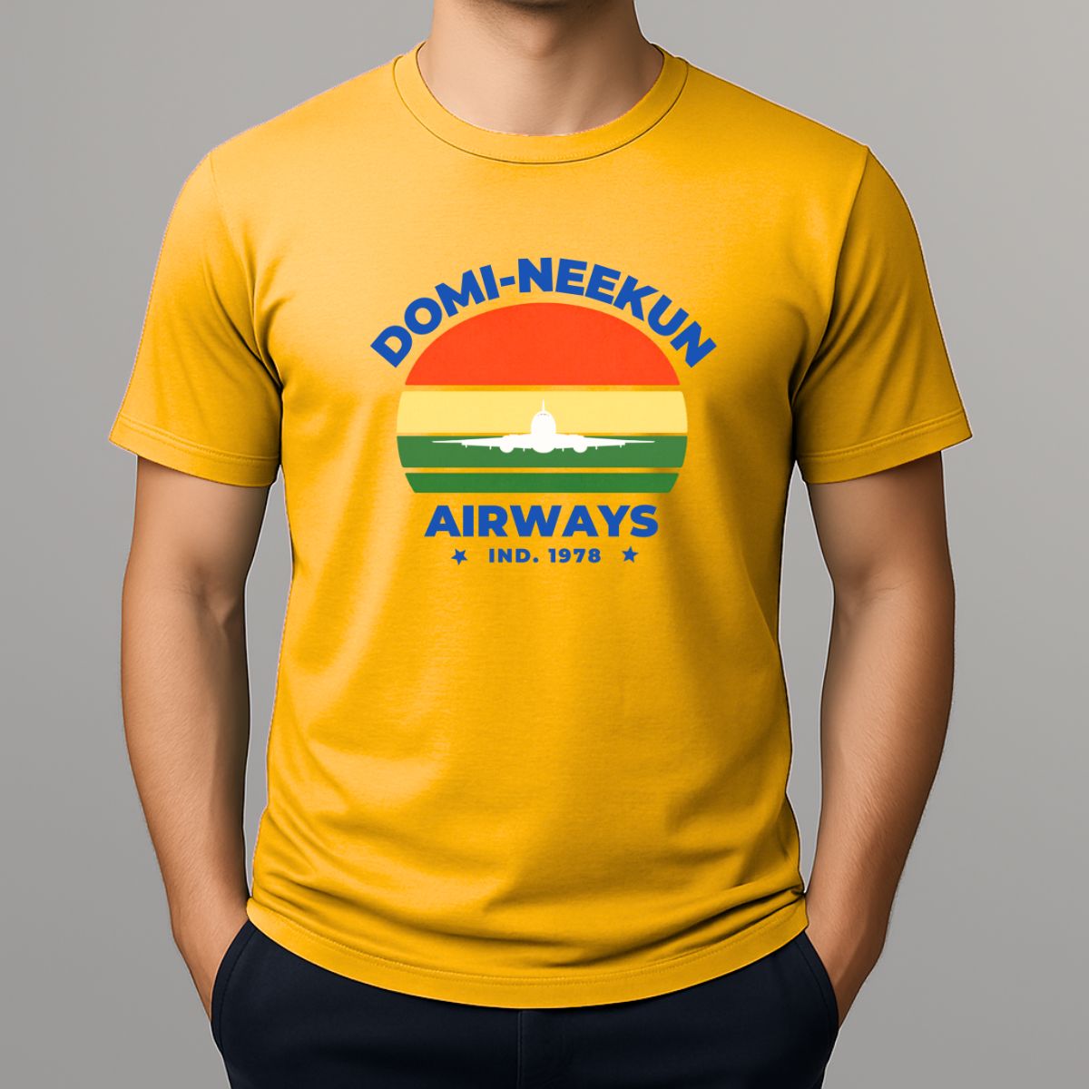 Person wearing a yellow short-sleeve T-shirt with a retro-style graphic reading 'DOMI-NEEKUN AIRWAYS' and 'IND. 1978' over a striped sunset and airplane silhouette.