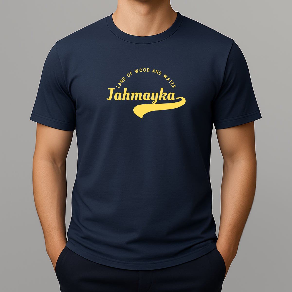 Person wearing a navy t-shirt with a yellow graphic that phonetically spells Jamaica as 'Jahmayka' and 'LAND OF WOOD AND WATER'.