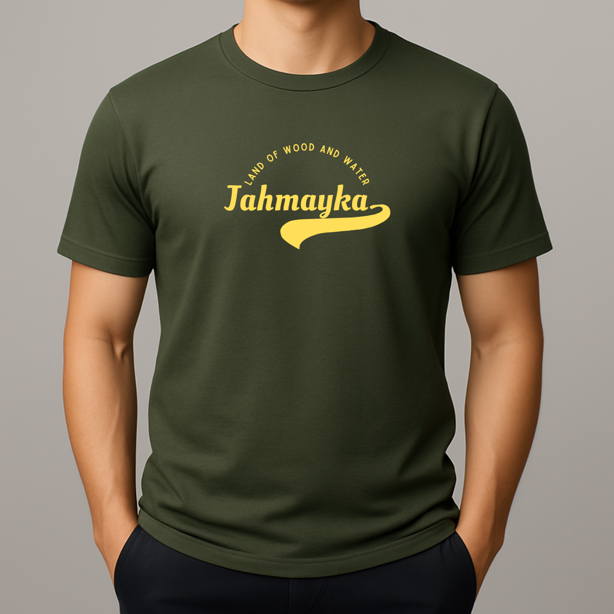 Person wearing a khaki green t-shirt with a yellow graphic that phonetically spells Jamaica as 'Jahmayka' and 'LAND OF WOOD AND WATER'.