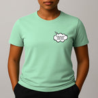Person wearing a mint green short-sleeve t-shirt with a comic style thought bubble on the left chest. Black text reads "MORE BLACKS, MORE DOGS, MORE IRISH".