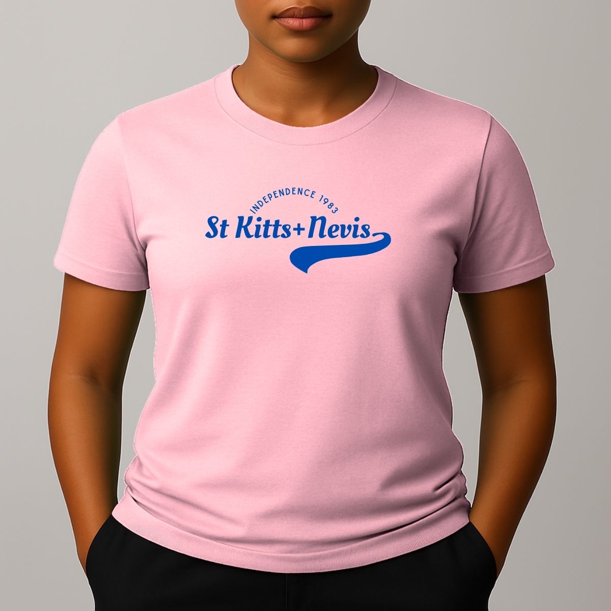 Person wearing a pink short sleeve t-shirt with a blue 'St Kitts+Nevis' graphic on the chest.
