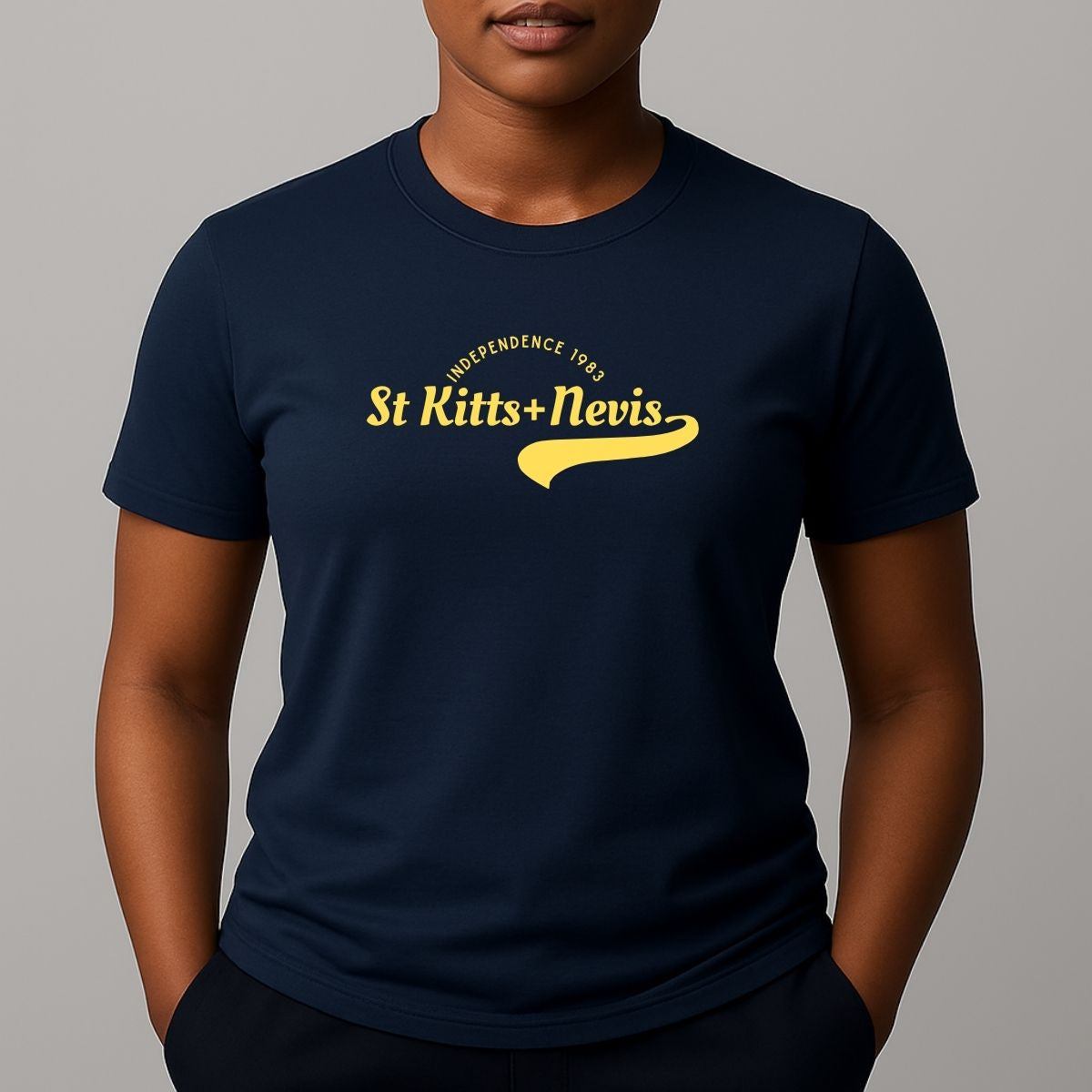 Person wearing a navy short sleeve t-shirt with a yellow 'St Kitts+Nevis' graphic on the chest.