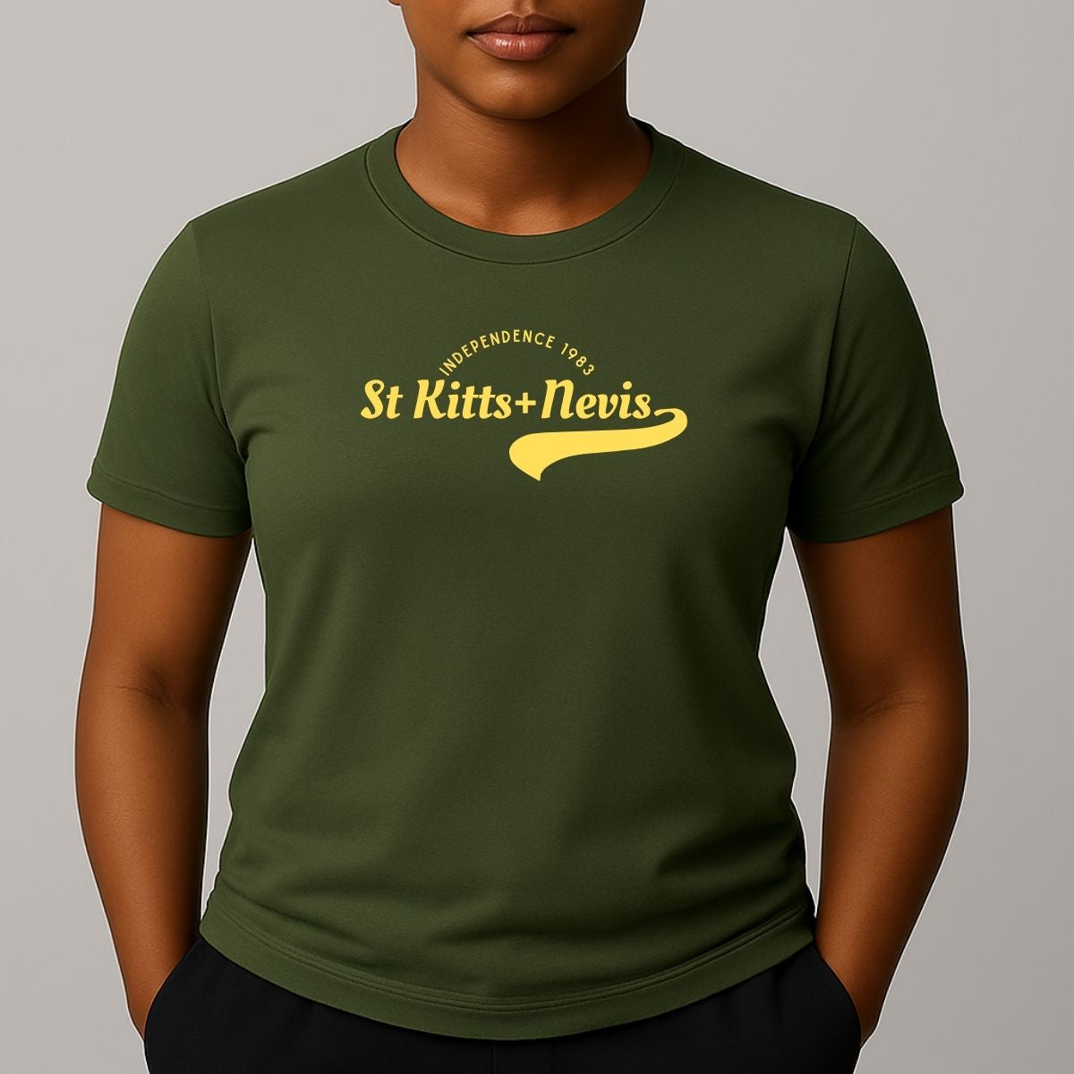 Person wearing a khaki green short sleeve t-shirt with a yellow 'St Kitts+Nevis' graphic on the chest.