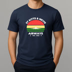 Person wearing a navy t-shirt with a graphic print on the chest, featuring the text 'ST KITTS & NEVIS AIRWAYS' in white, surrounding a circular flag design with red, yellow, and green horizontal bands and a white airplane silhouette.