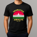 Person wearing a black T-shirt with a colorful front graphic that reads "TRINBAYGO AIRWAYS IND. 1962" with an airplane silhouette.
