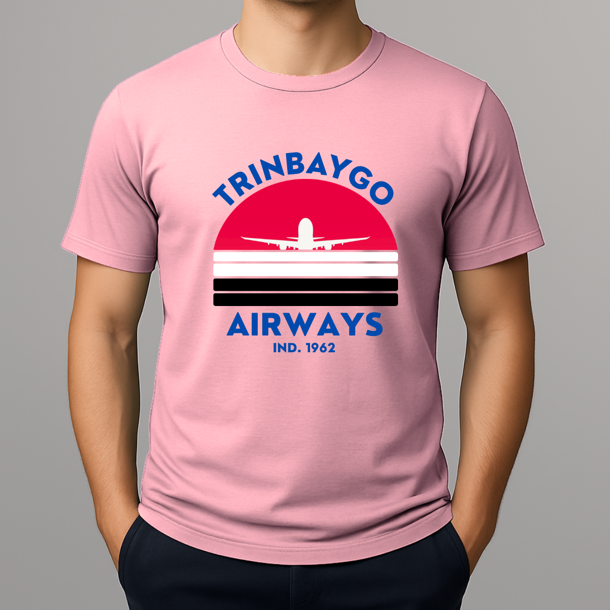 Person wearing a pink T-shirt with a colorful front graphic that reads "TRINBAYGO AIRWAYS IND. 1962" with an airplane silhouette.