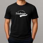 Person wearing a black t-shirt with a white graphic print with a phonetic spelling that reads 'Trinbaygo' and 'LAND OF THE HUMMINGBIRD'.