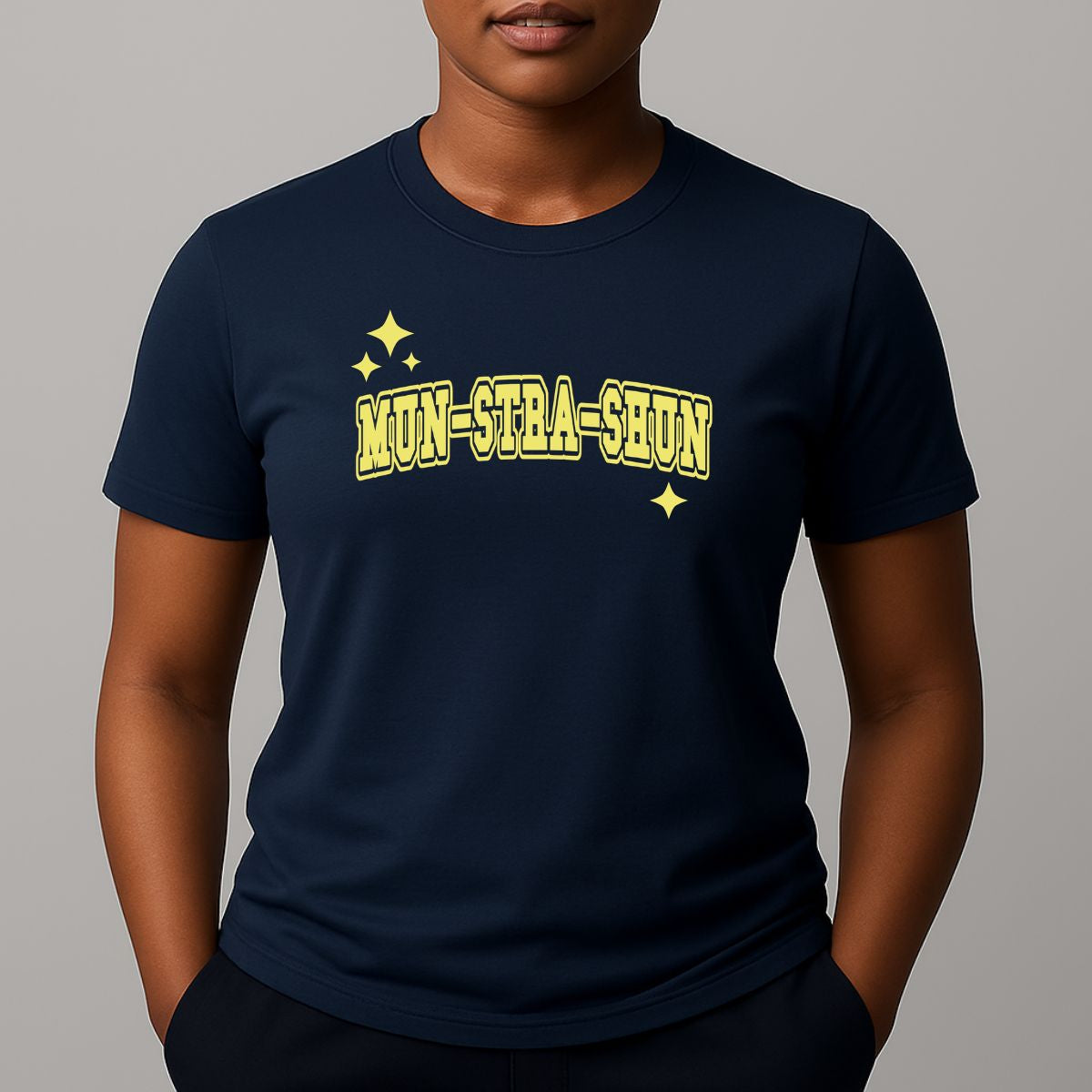 Person wearing a navy t-shirt with 'MUN-STRA-SHUN' printed in yellow on a gray background