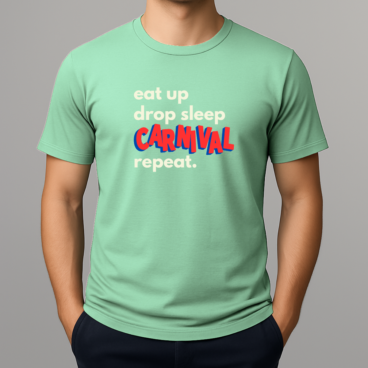Person wearing a mint green t-shirt with a colorful graphic text in white, blue and red that reads 'eat up drop sleep CARNIVAL repeat.'