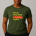 Person wearing a khaki green t-shirt with a colorful graphic text in yellow and red that reads 'eat up drop sleep CARNIVAL repeat.'