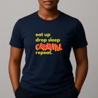 Person wearing a navy t-shirt with a colorful graphic text in yellow and red that reads 'eat up drop sleep CARNIVAL repeat.'